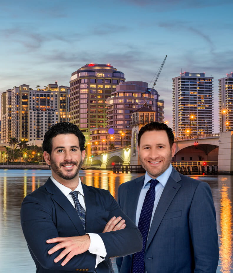 Winegar attorneys in suits standing in front of a body of water with buildings in the background