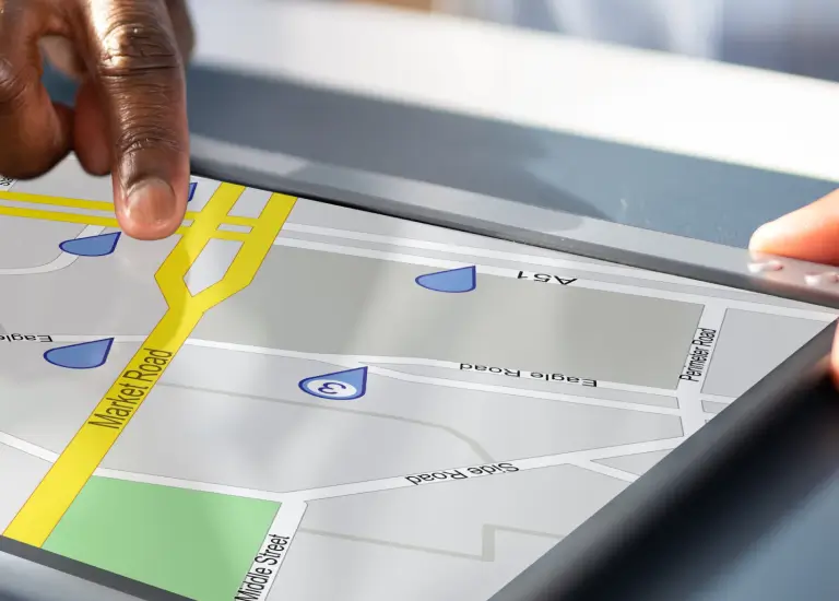 a hand touching a map on a tablet